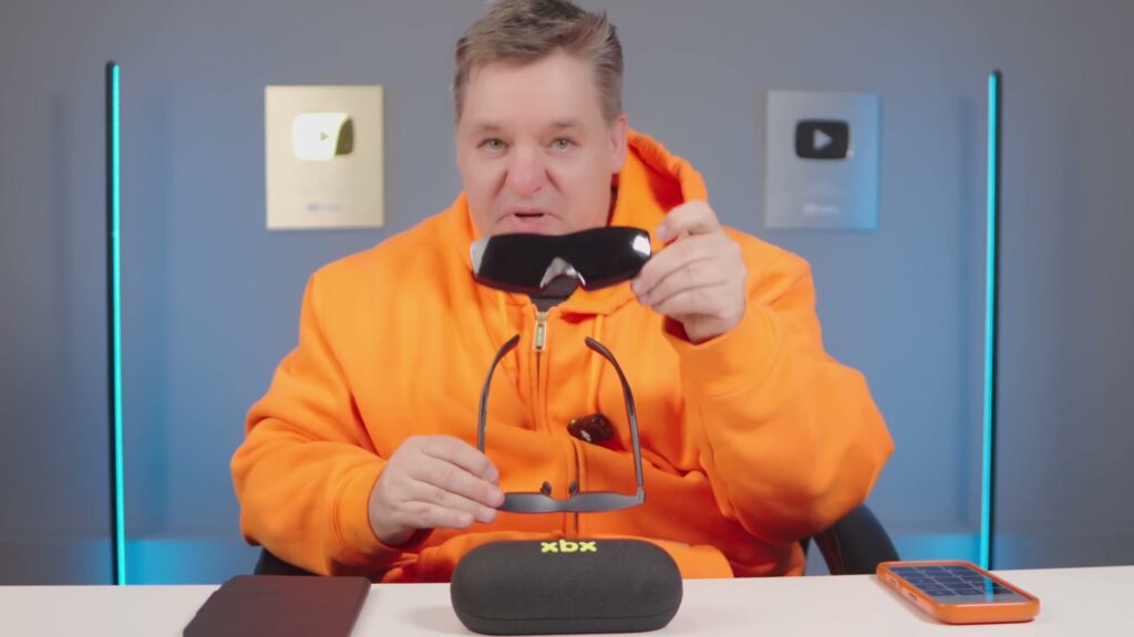 Curtis Pyke holding the removable XREAL xbx a01+ light shield beside the glasses