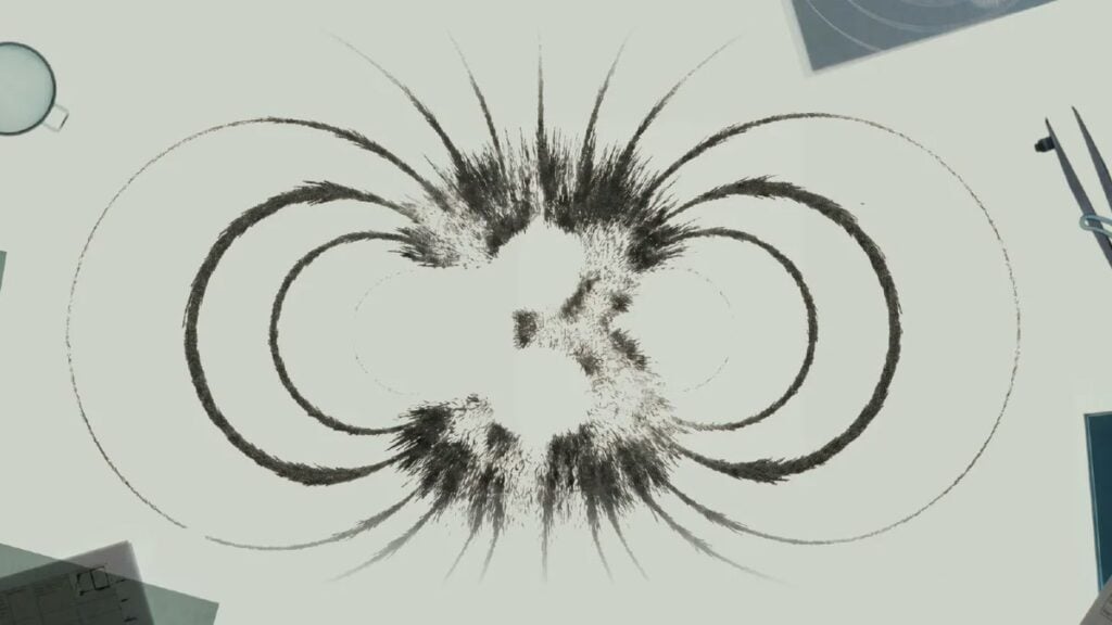 Magnetic filings form the symmetrical Kimi K3 launch mark on a pale work surface